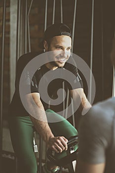 Young man exercise on stationary bikes in fitness class.