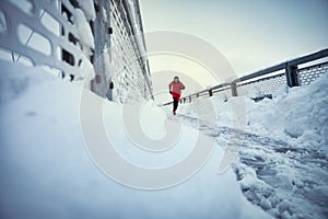 Young man exercising on bridge cowered with snow