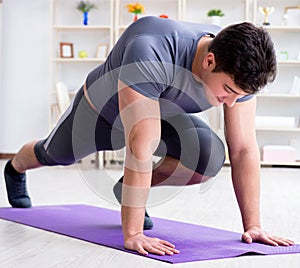 Young man exercising at home in sports and healthy lifestyle con