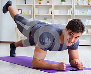 Young man exercising at home in sports and healthy lifestyle con