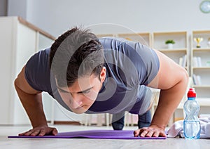 Young man exercising at home in sports and healthy lifestyle con