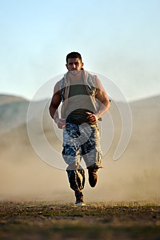 Young man exercising outdoor on dusty field