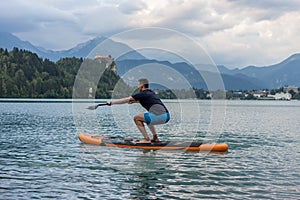 Young man exercising on paddle board at the lake
