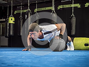 Young man exercising pecs in gym with push-ups