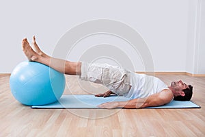 Young Man Exercising On A Pilates Ball