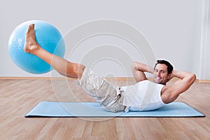 Young man exercising on a pilates ball