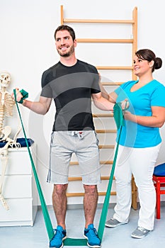 Young man exercising with resistance band in physical therapy