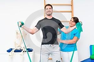 Young man exercising with resistance band in physical therapy