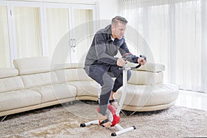 Young man exercising on a spin bike at home