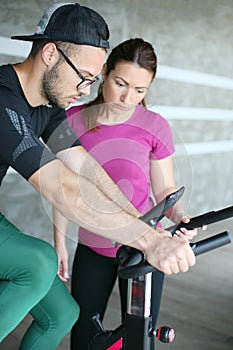 Young man exercising on stationary bikes.