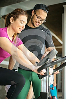 Young man exercising on stationary bikes.