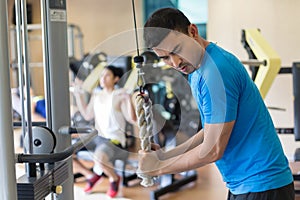 Young man exercising triceps pushdown during intense workout at the gym