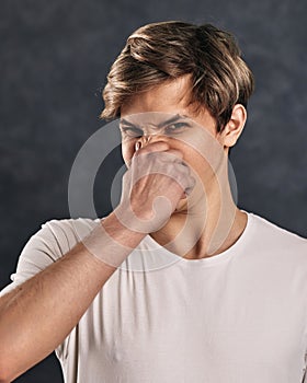 young man expressing negativity on gray background.