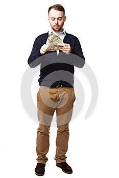 Young man eyeing up a handful of money