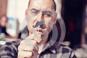 Young man with a fake moustache