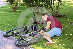 Young man fallen off his bicycle in park