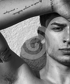 Young man fashion portrait. Handsome male close up. Black and white portrait of sexy muscular guy, looking at camera