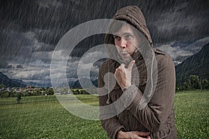 Young man feeling cold during thunderstorm