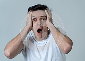 Portrait of a young man looking scared and shocked. Human expressions and emotions