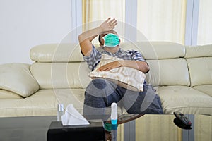 Young man feeling unwell with face mask at home