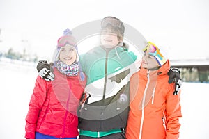 Young man with female friends standing arm around in snow