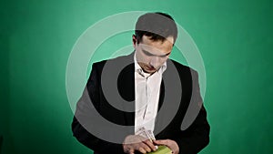 A young man finds money in a book. green background