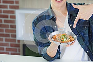 Young man fingers point to fried egg with colorful toppings served on pan