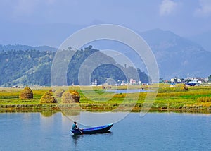 Young man fishing on a lake from the boat