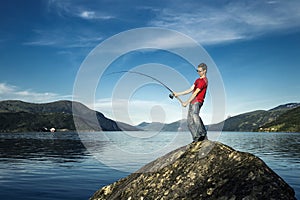 Young man is fishing in Norway