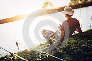 Young man fishing at pond and enjoying hobby