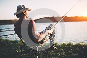 Young man fishing at pond and enjoying hobby photo