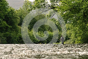 Young man fishing trouts in the river