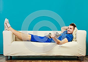 Young man fit body relaxing on couch after training