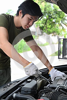 Young man fixing car in the garage.