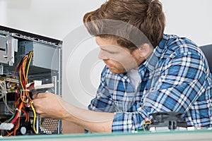 Young man fixing computer