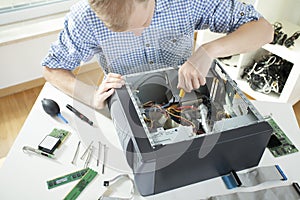 Young man fixing computer photo