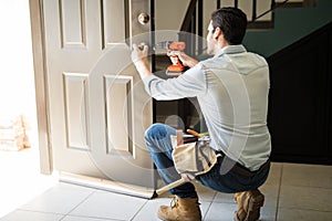 Young man fixing a door lock