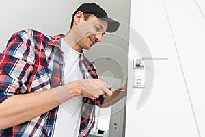 Young man fixing a door lock