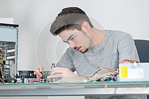 young man fixing electronic circuits closeup