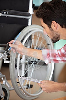 young man fixing wheelchair photo