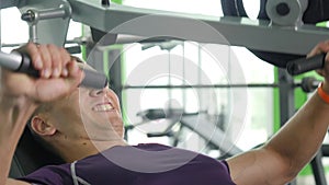 Young man flexing chest muscles on gym machine