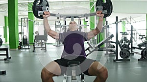 Young man flexing chest muscles on gym machine