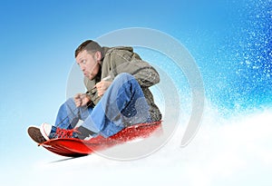 Young man flies on sled in the snow photo