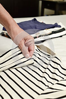 Young man folding clothes