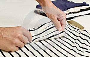 Young man folding clothes photo