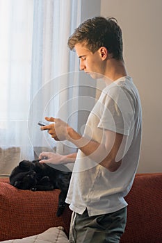 Young man follows online courses on the phone, at home during the Covid epidemic