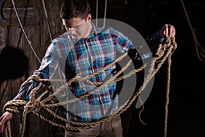 Young man freed from captivity and selecting from ropes