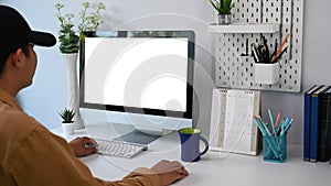 Young man freelancer in black hat working on computer at home office.