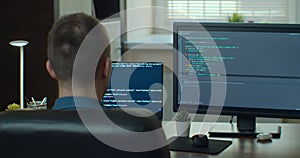 Young man freelancer coding html and programming on two screen Monitors, development web, developer.