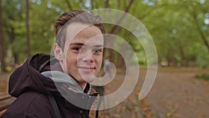 Young man freelancer student using laptop studying online working from park in internet, smiling focused millennial guy